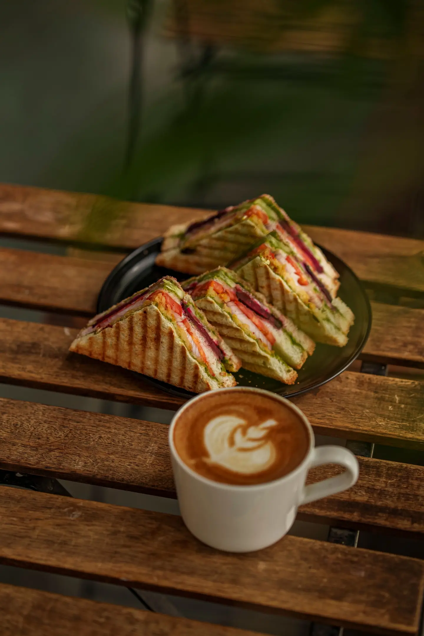 Toasted sandwiches and a cappuccino on a wooden table